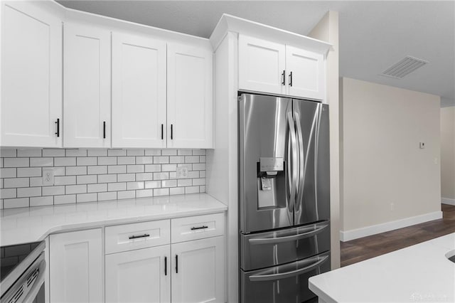 kitchen featuring white cabinets, stainless steel fridge, and decorative backsplash