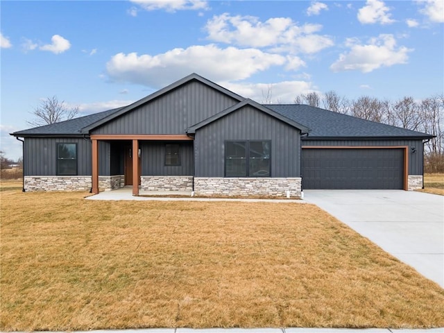 modern farmhouse featuring an attached garage, a front lawn, driveway, and stone siding