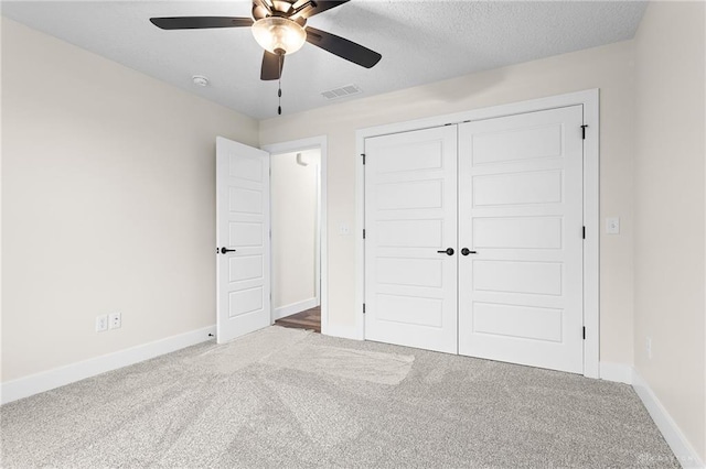 unfurnished bedroom featuring carpet flooring, a textured ceiling, ceiling fan, and a closet