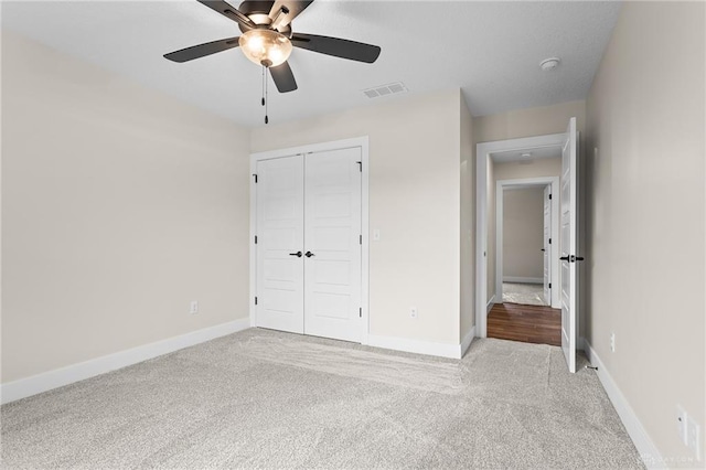 unfurnished bedroom with ceiling fan, a closet, and light carpet