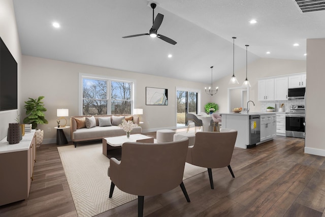 living area featuring visible vents, baseboards, ceiling fan with notable chandelier, and dark wood-style floors