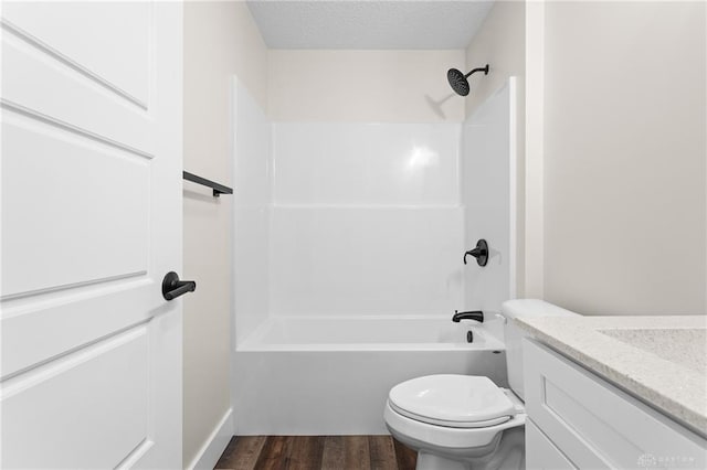 full bathroom with toilet,  shower combination, a textured ceiling, vanity, and hardwood / wood-style floors