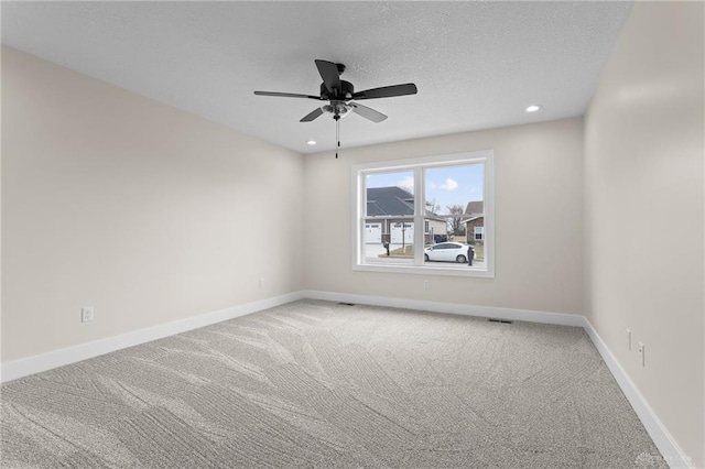 carpeted empty room featuring a textured ceiling and ceiling fan