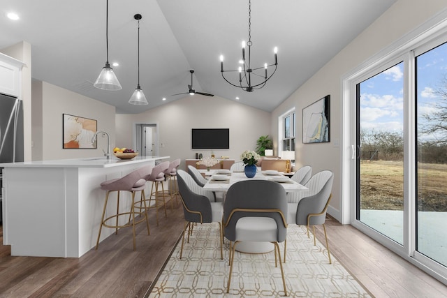 dining space with light wood finished floors, lofted ceiling, and a healthy amount of sunlight