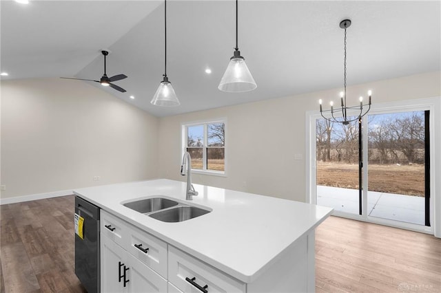 kitchen featuring sink, white cabinetry, hanging light fixtures, dishwasher, and a kitchen island with sink