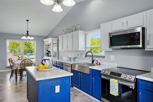 1627 Metcalfe Ave, Columbus, OH 43207 - kitchen featuring stainless steel appliances, a chandelier, blue cabinetry, lofted ceiling, and a kitchen island