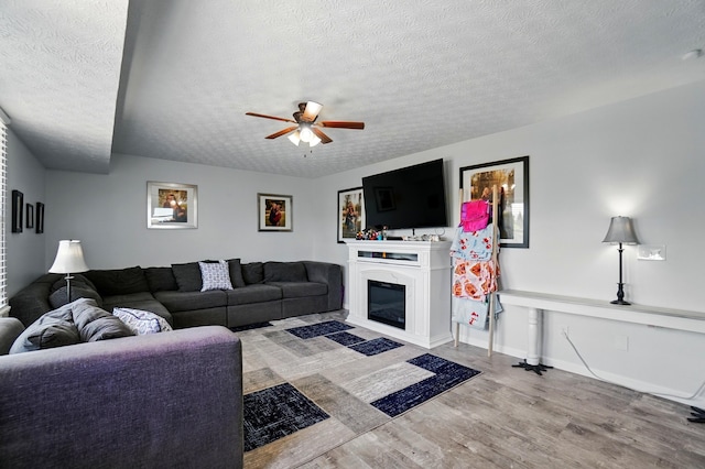 1627 Metcalfe Ave, Columbus, OH 43207 - living room featuring ceiling fan, a textured ceiling, wood finished floors, and a glass covered fireplace