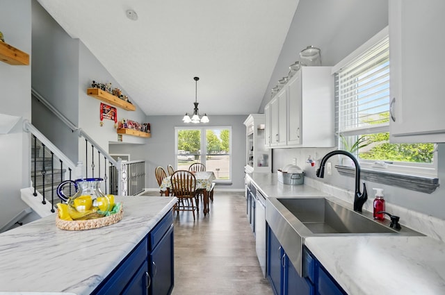 1627 Metcalfe Ave, Columbus, OH 43207 - kitchen with blue cabinetry, a chandelier, light wood-style floors, stainless steel dishwasher, and high vaulted ceiling
