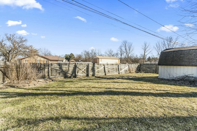 view of yard featuring an outbuilding, a fenced backyard, and a shed