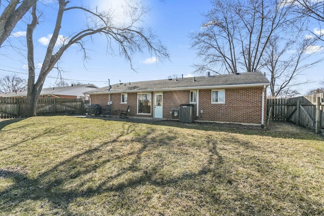 back of house with a patio, a fenced backyard, central AC, a lawn, and brick siding