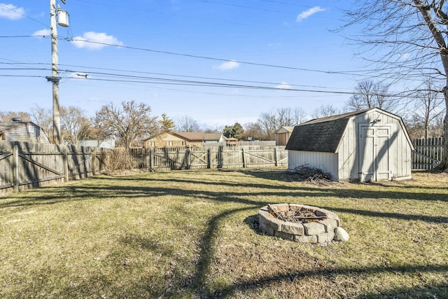 view of yard featuring a storage unit, a fire pit, a fenced backyard, and an outdoor structure