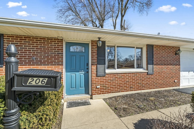 property entrance featuring brick siding and an attached garage