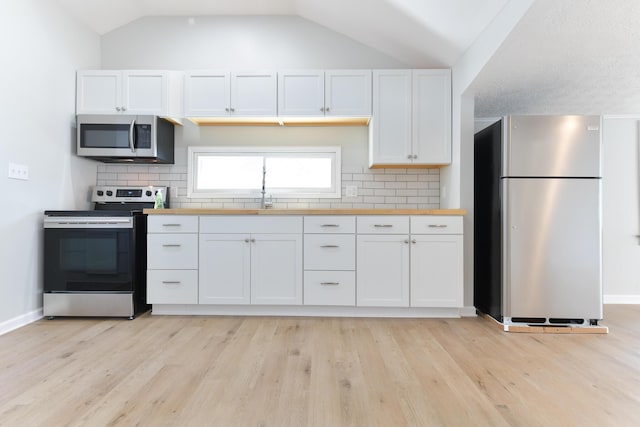 127 Brads Way, Russells Point, OH 43348 - kitchen featuring appliances with stainless steel finishes, light wood-type flooring, lofted ceiling, white cabinets, and tasteful backsplash