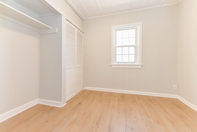 127 Brads Way, Russells Point, OH 43348 - unfurnished bedroom with light wood finished floors, a closet, and crown molding