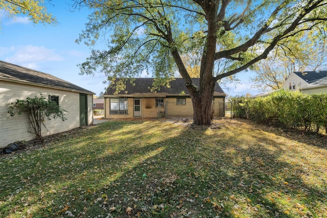 back of property with a yard and brick siding