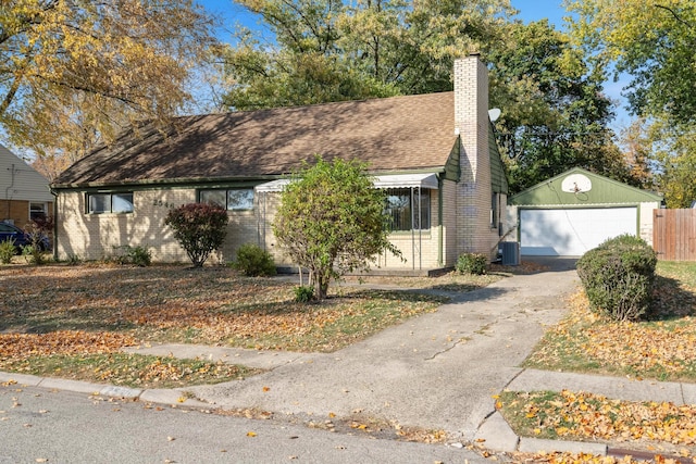 ranch-style home with a garage, a chimney, roof with shingles, cooling unit, and brick siding