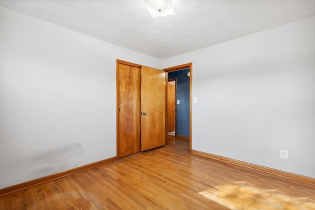 empty room featuring light wood-style flooring and baseboards