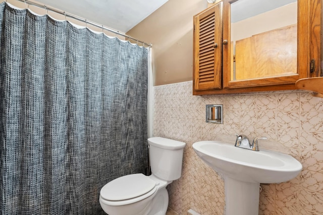 full bath featuring a shower with shower curtain, toilet, and tile walls