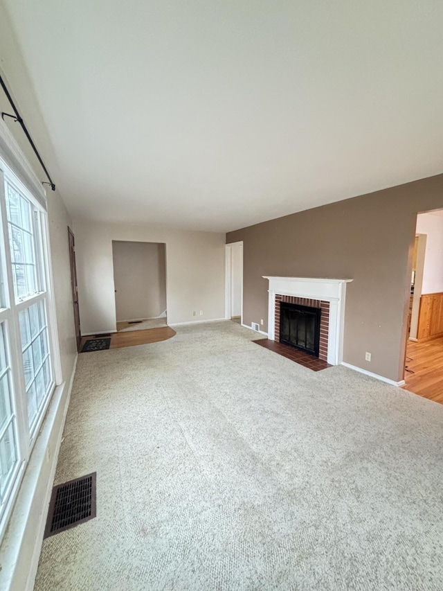 unfurnished living room with a fireplace, carpet floors, and vaulted ceiling