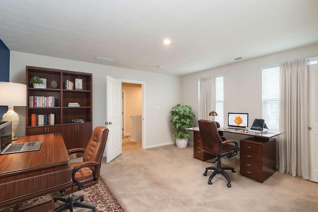 office area featuring visible vents, light carpet, and baseboards