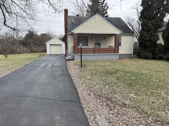 bungalow with a garage, an outdoor structure, a porch, and a front yard