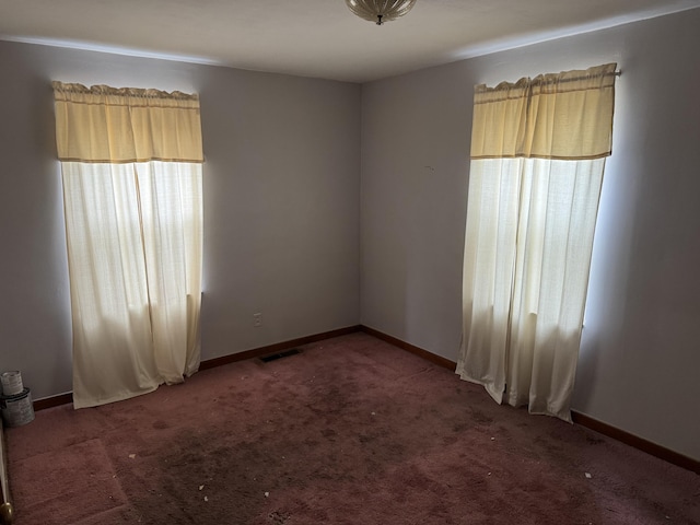 spare room with dark carpet