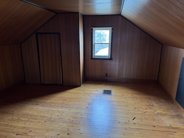 bonus room with wood ceiling, wood walls, vaulted ceiling, and light wood-type flooring