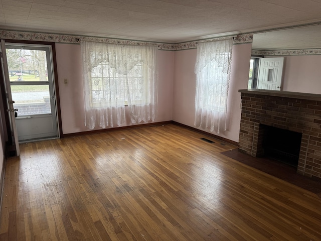 unfurnished living room with wood-type flooring and a fireplace