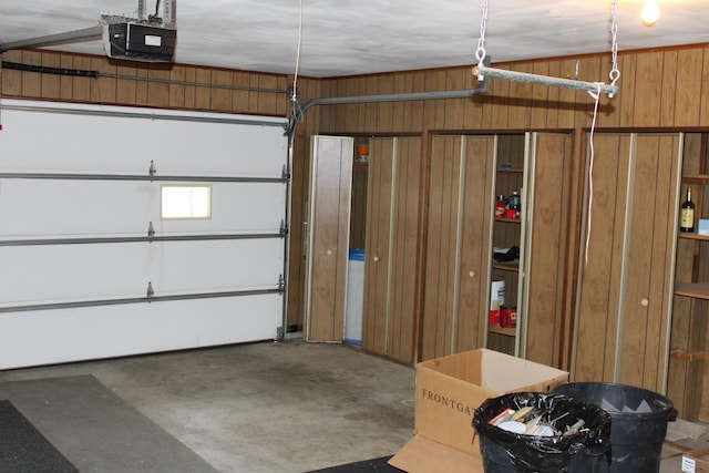 garage with a garage door opener and wooden walls