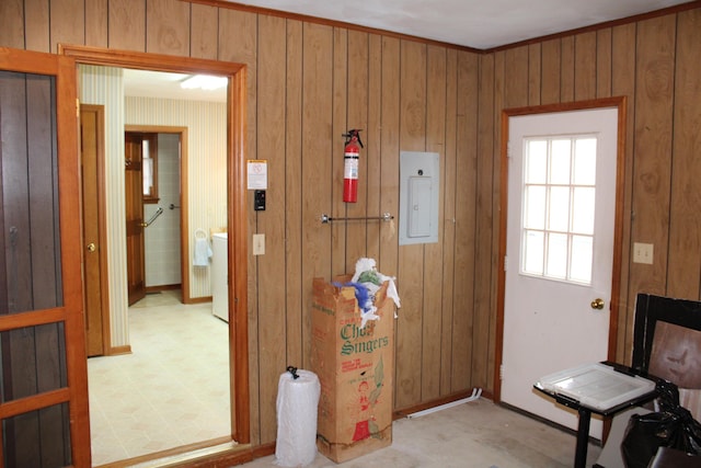 doorway with crown molding, electric panel, and wood walls