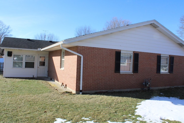 view of side of home with a yard