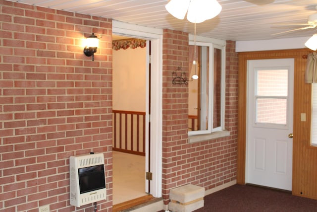 view of exterior entry featuring heating unit and ceiling fan