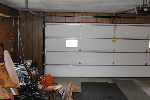 garage with a garage door opener and wood walls