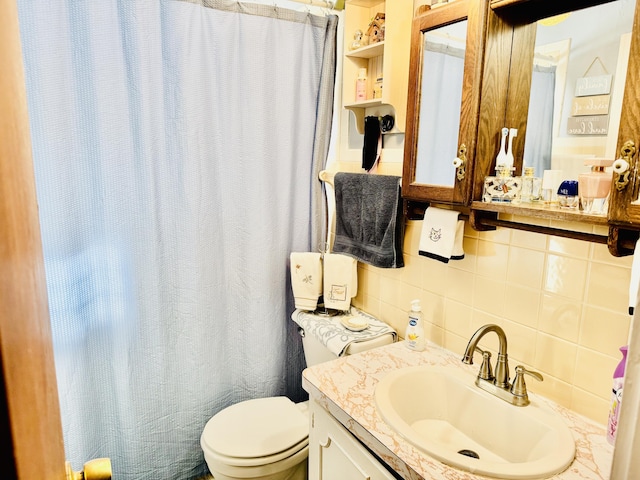 bathroom with tasteful backsplash, vanity, tile walls, and toilet