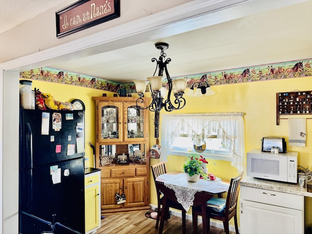 dining space with light hardwood / wood-style flooring and a notable chandelier