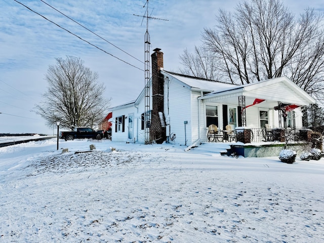 view of snowy exterior featuring a porch