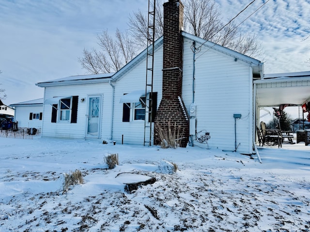 view of snow covered back of property