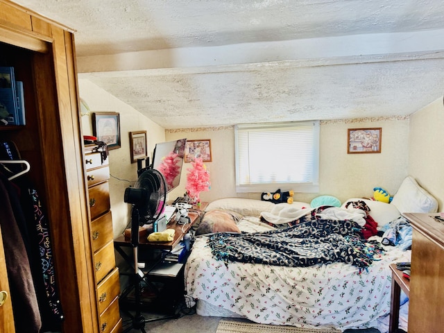 bedroom featuring lofted ceiling, carpet, and a textured ceiling