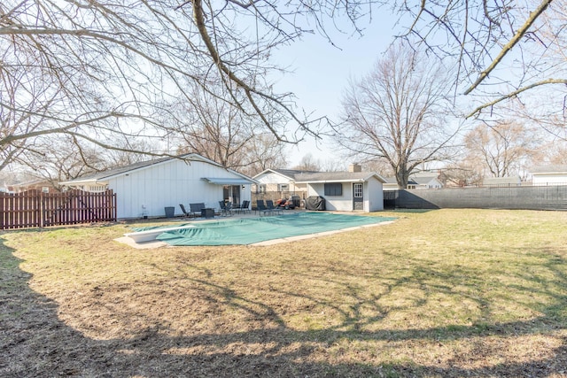 view of swimming pool with a fenced in pool, a fenced backyard, an outdoor structure, a patio area, and a lawn