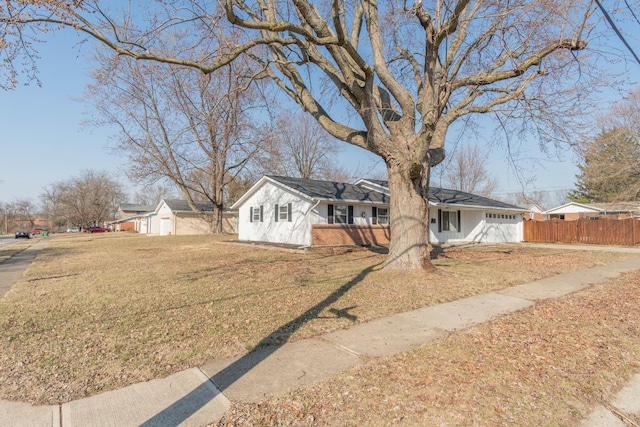 ranch-style house featuring a garage, a front yard, and fence