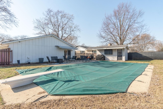 view of pool with a fenced in pool, a fenced backyard, a diving board, a patio area, and a grill