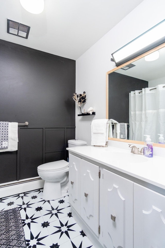 bathroom with tile patterned floors, visible vents, toilet, a baseboard heating unit, and vanity