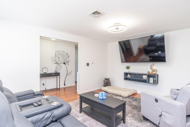 living area featuring wood finished floors, visible vents, and baseboards