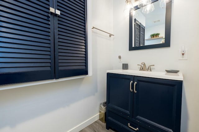 bathroom featuring vanity, baseboards, and wood finished floors