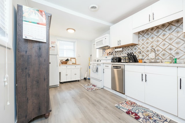 kitchen featuring tasteful backsplash, light countertops, visible vents, white cabinetry, and white appliances