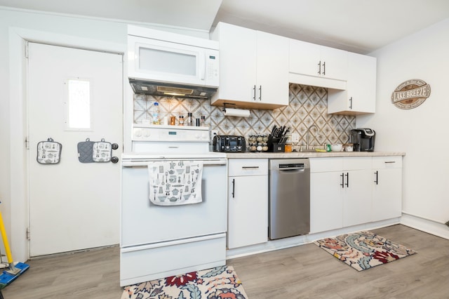 kitchen with white appliances, tasteful backsplash, white cabinets, light countertops, and light wood-type flooring