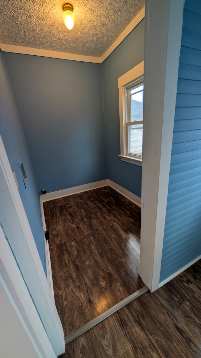 spare room featuring dark hardwood / wood-style flooring and a textured ceiling