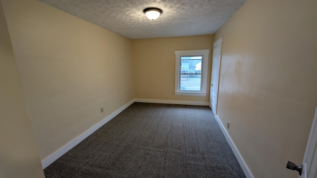 carpeted empty room featuring a textured ceiling