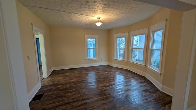 unfurnished dining area featuring dark wood-type flooring and a textured ceiling