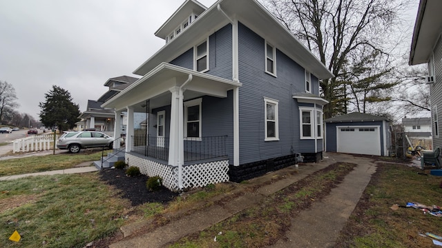 view of front of property featuring an outbuilding, a garage, a front yard, and covered porch